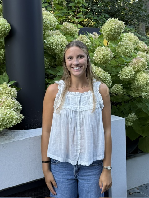 Portrait of Amelia Holderness outdoors in front of hydrangeas